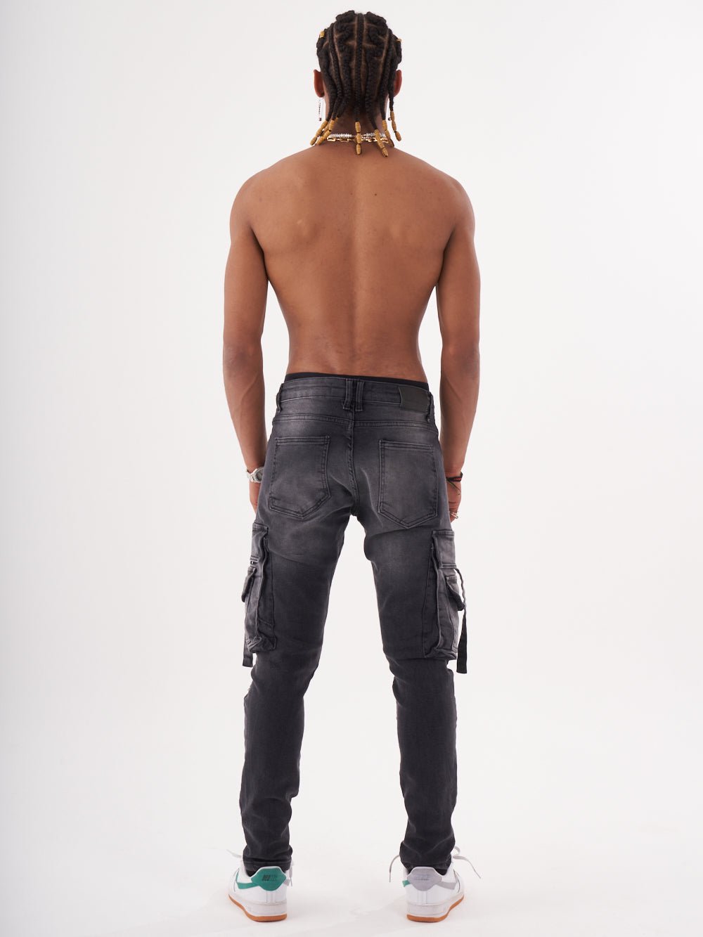 The back view of a man wearing black denim HIPSTER cargo pants.