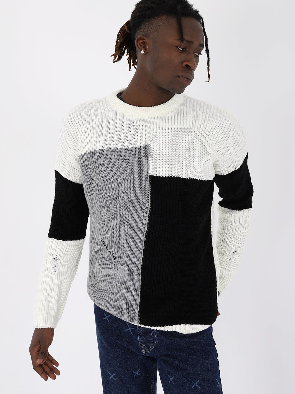A man wearing a DISTRESSED GENTLEMAN SWEATER | MULTICOLOR in black, white, and grey.