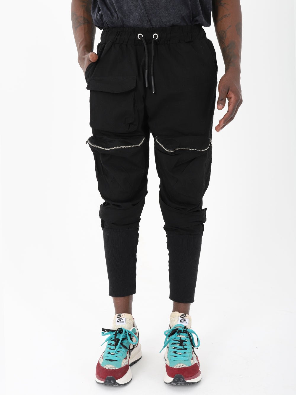A man wearing Mereen jogger pants and sneakers.