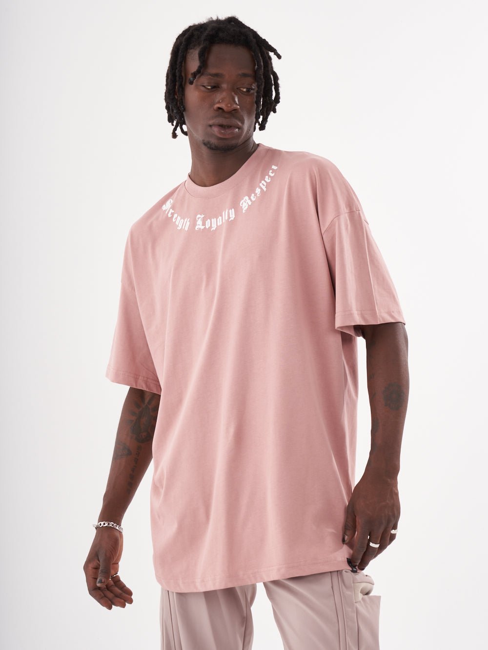 A man wearing a CREED T-SHIRT and pants.
