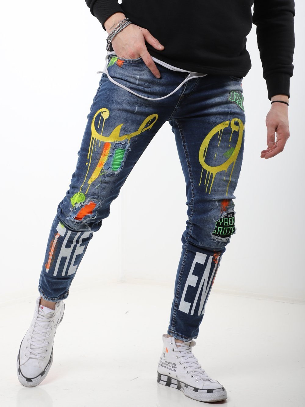 A man wearing a pair of MY WAY jeans with graffiti on them.